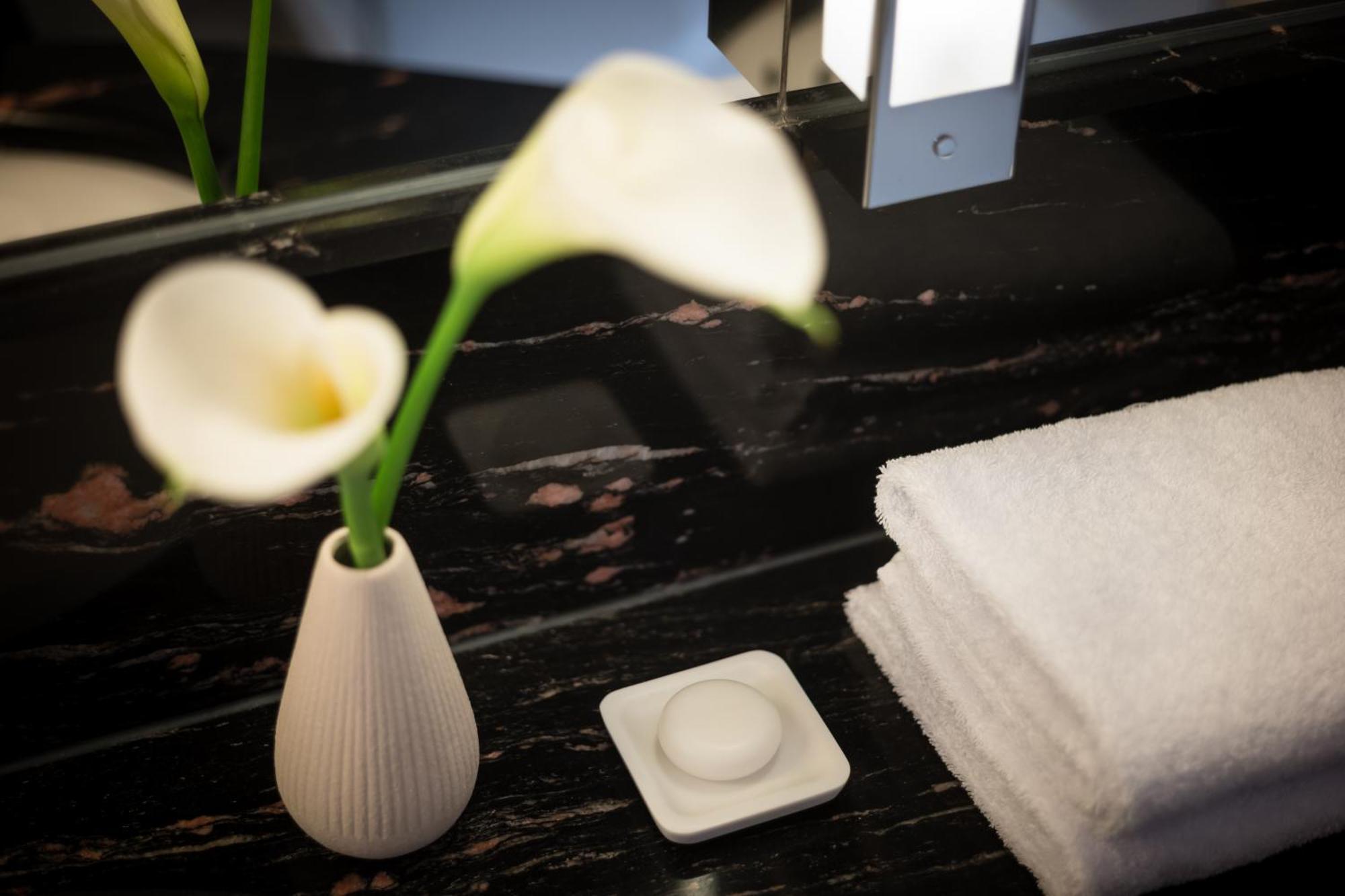 Grand Elysee Hamburk Exteriér fotografie A small vase of flowers in a hotel room